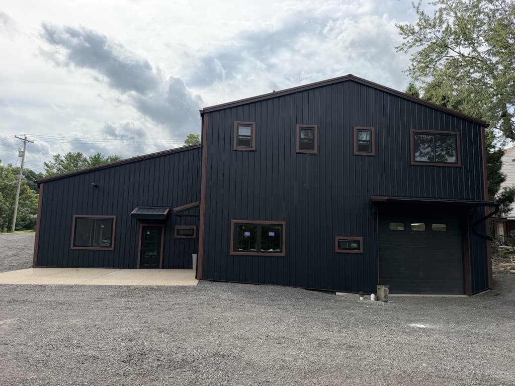 Front view of commercial building with black vertical ribbed metal siding