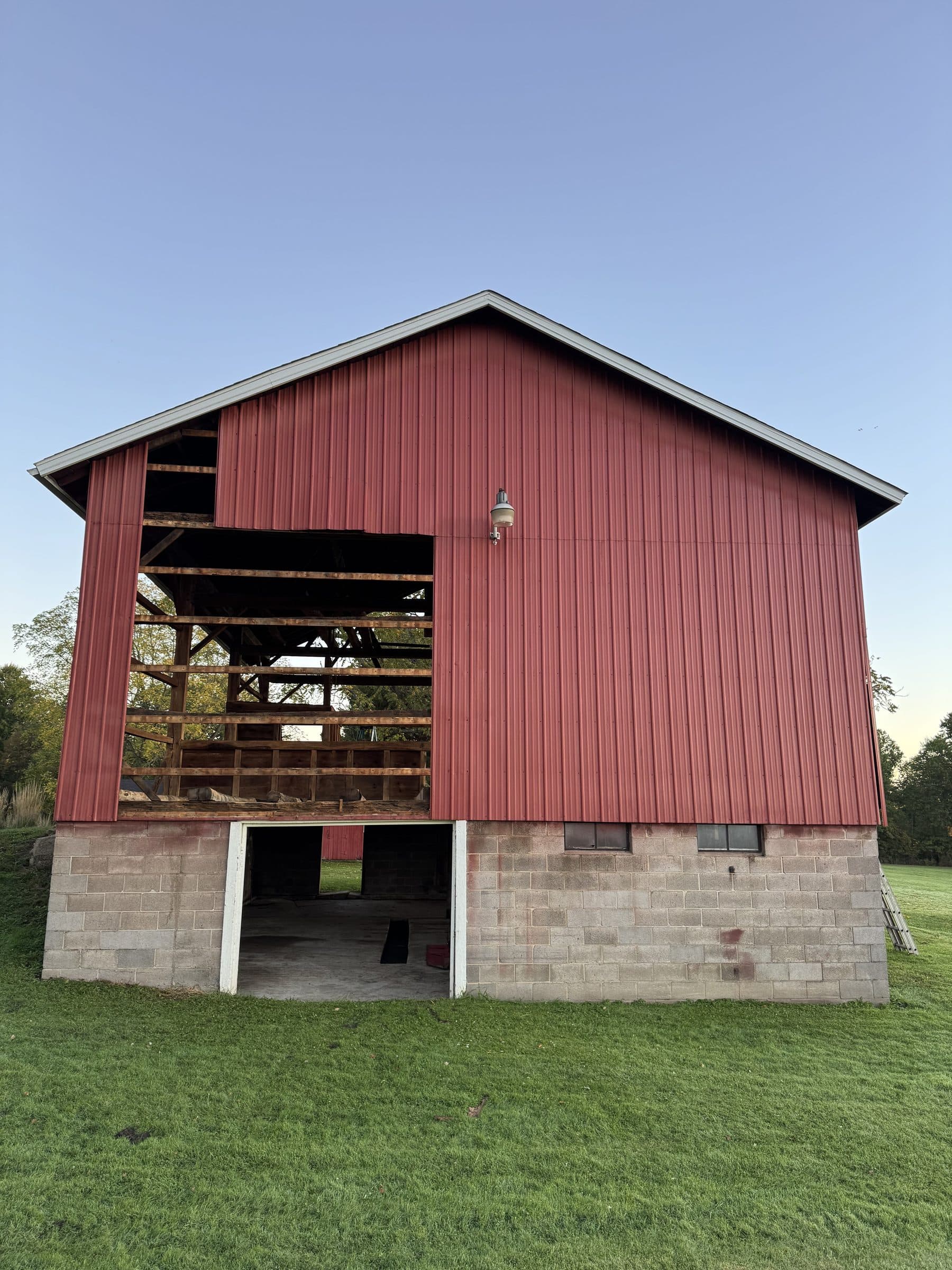Gable end of the barn with aging red metal siding