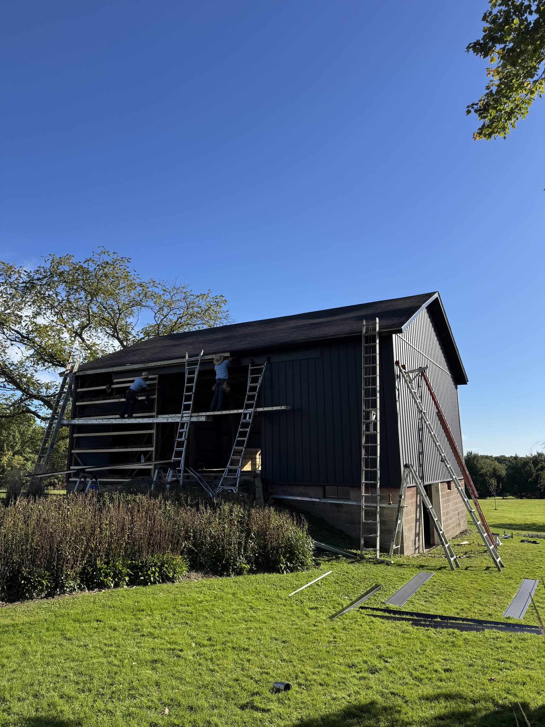 Scaffolding along the barn during black metal siding install