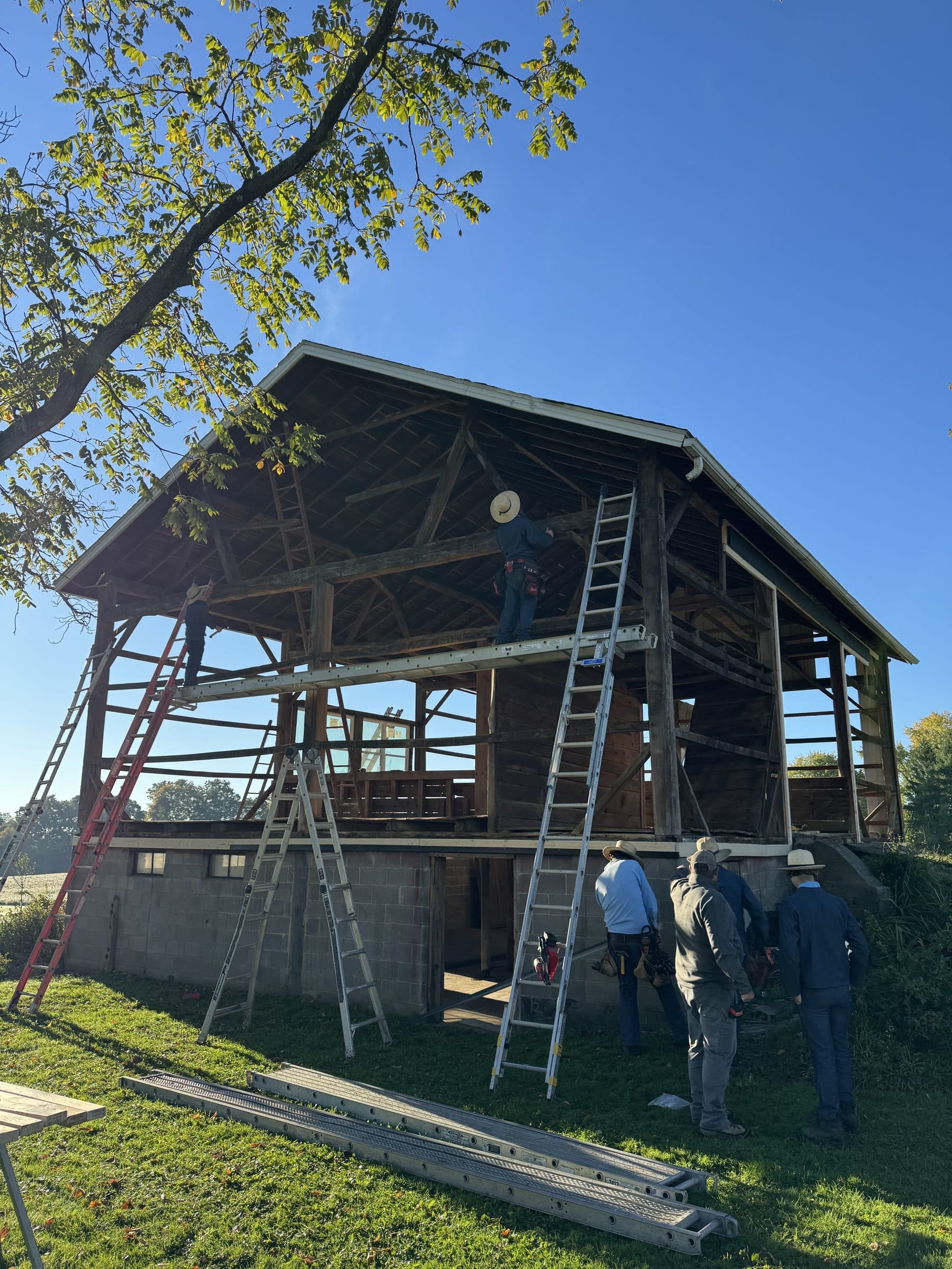 Crew working with the barn framing exposed