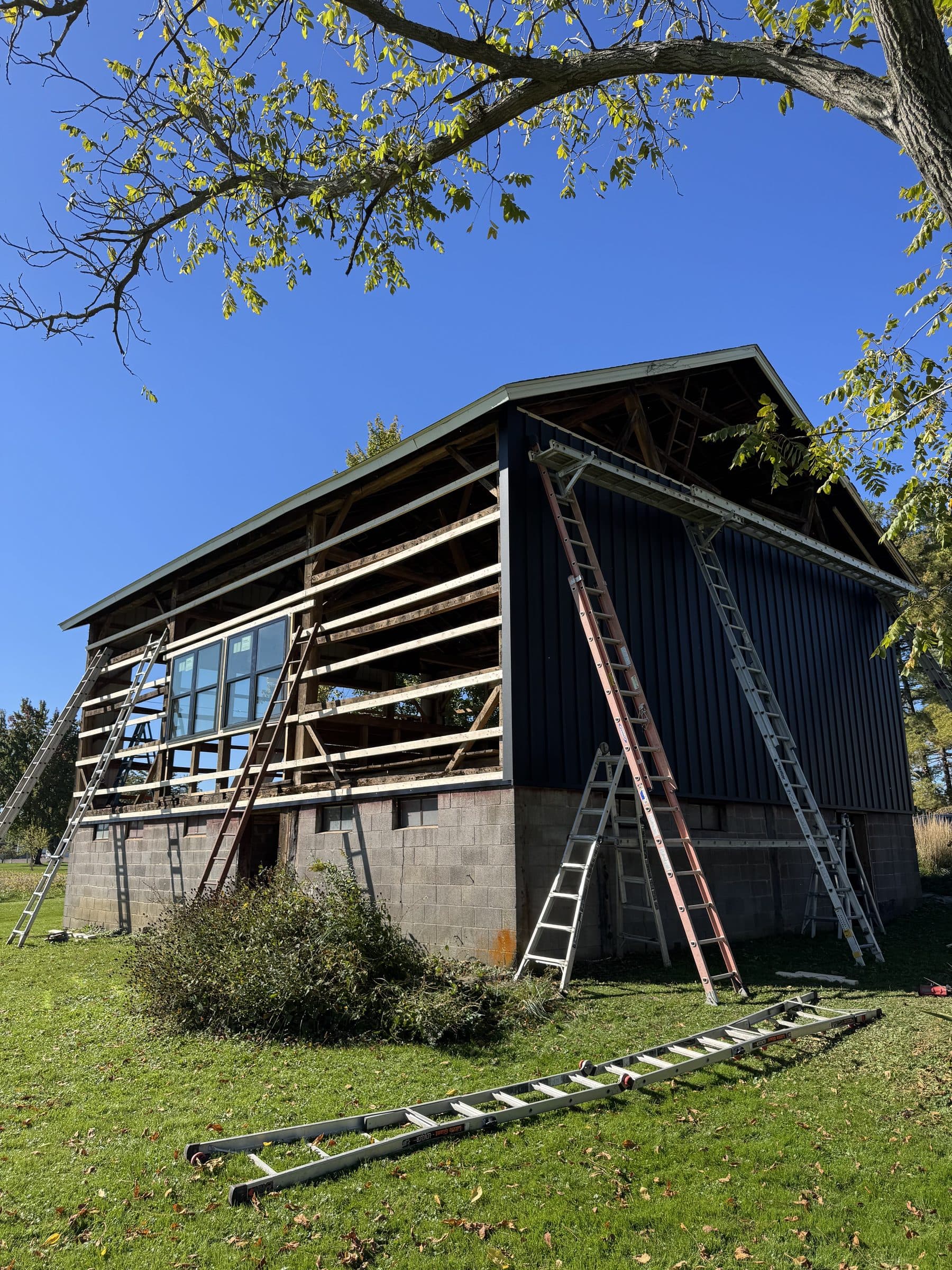 Barn with black siding on the gable and framing still open on the side