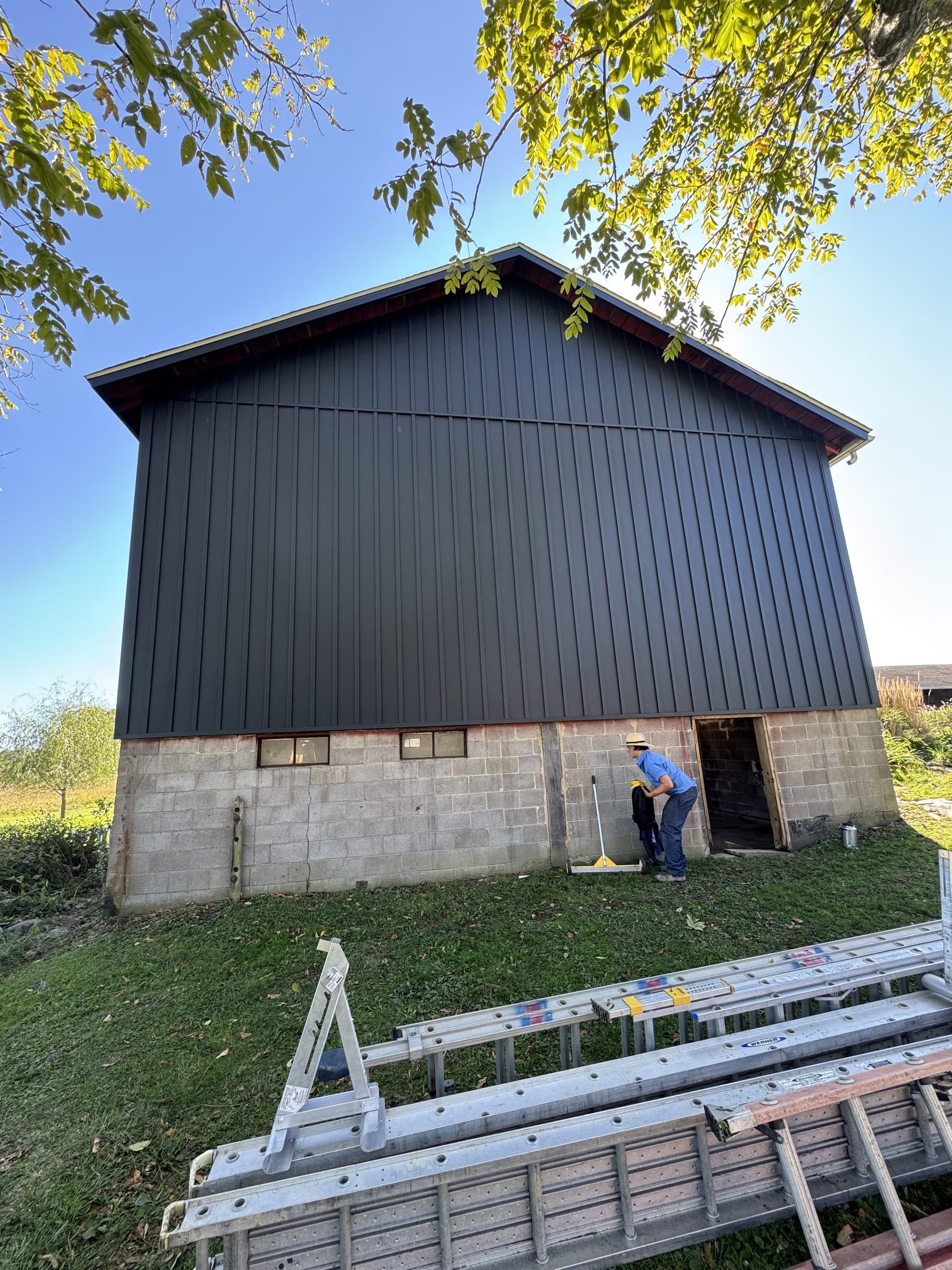 Completed barn gable with black vertical metal siding